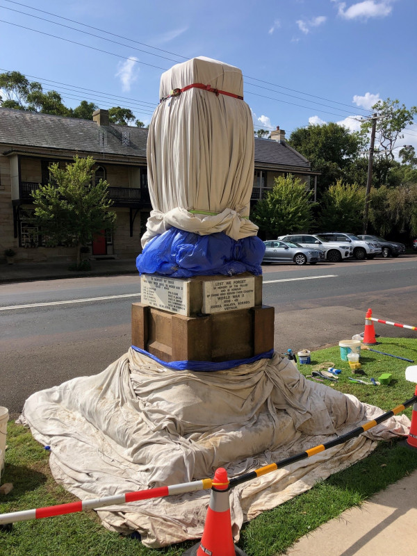 Memorial covered in damp hessian and plastic wrapping for two-week aftercare.